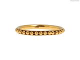 gros plan d'une bague en or sur fond blanc