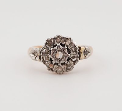 an antique diamond cluster ring in white gold and silver