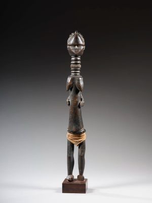 une statue en bronze représentant une femme tenant un bol sur la tête