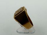 an image of a gold ring on a clear stand on a white surface