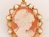 un gros plan sur un pendentif camée en or et corail orné de perles
