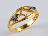 un gros plan d'une bague en or sertie de pierres noires