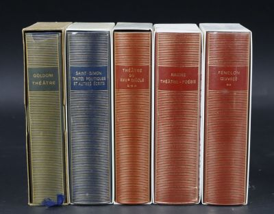 four books are lined up in a row on a black surface