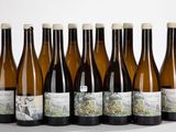 six bouteilles de vin sont alignées sur une table