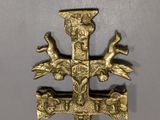 a gold cross with birds on it on a table