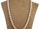 a white pearl necklace on a mannequin with a gold clasp