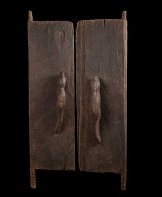 une paire de portes en bois ornées de sculptures sur fond noir