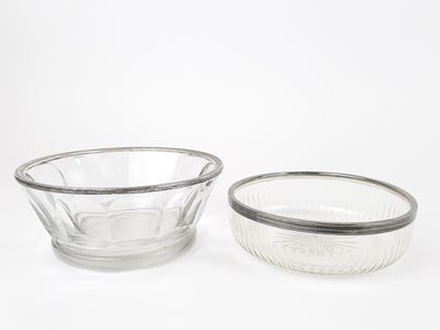 deux bols en verre transparent bordés d'argent, posés sur un plan de travail blanc