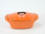 an orange casserole dish with a black handle on a white background