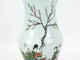 un vase avec un tableau posé sur une table