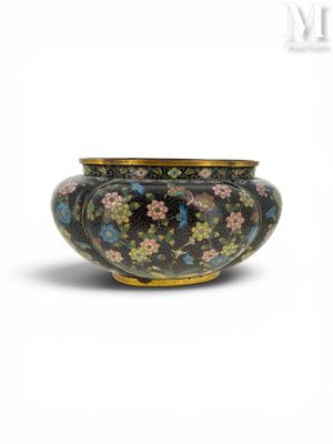 une image représentant un vase noir et doré orné de fleurs
