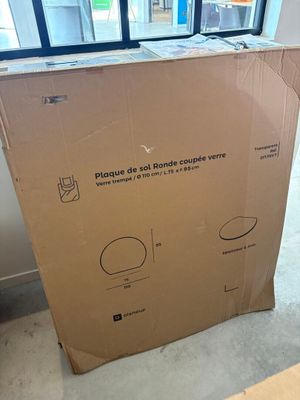 un grand carton posé par terre devant une fenêtre