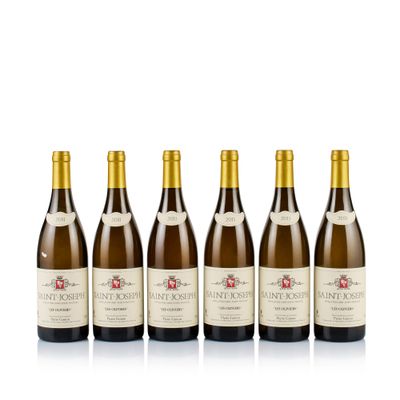 six bottles of wine lined up in a row on a white surface