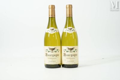 two bottles of white wine sitting next to each other on a white surface