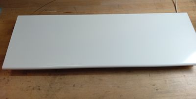 un ordinateur portable blanc posé sur une table en bois