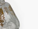 a clear glass vase with a gold design on it