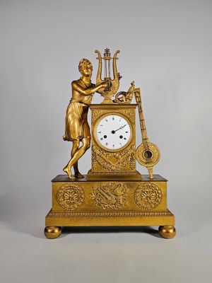 une horloge en or représentant un homme jouant d'un instrument de musique