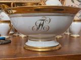a white and gold bowl sitting on a wooden table