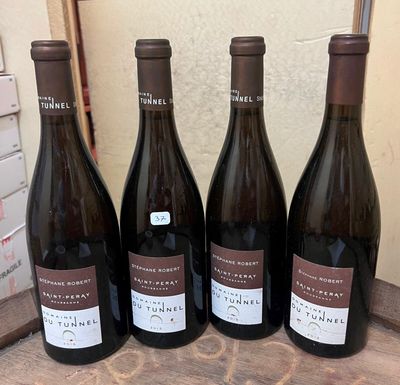 four bottles of wine are lined up on a wooden table