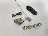 a group of silver and gold jewelry on a white surface