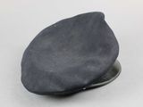 grey flat cap on a silver plate on a white surface