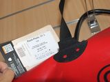 a red bag with a ticket attached to it
