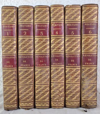 six vieux livres sont alignés sur une table