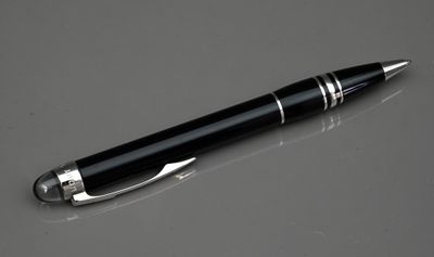 une image représentant un stylo posé sur une table, à côté d'un téléphone portable