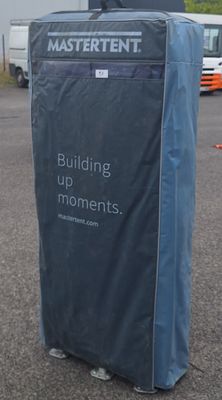 un couvercle bleu posé sur une boîte noire au milieu d'un parking