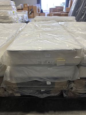 many mattresses stacked on a pallet in a warehouse