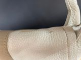 the back of a white purse on a table with a black background