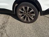 the rear end of a white suv parked in a parking lot