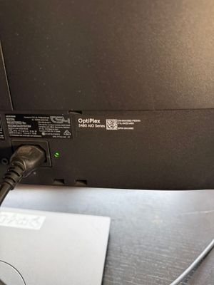 un ordinateur portable posé sur un bureau, avec un câble qui y est branché
