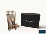 a close up of a pair of chanel earrings in front of a box