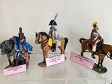 five figurines of soldiers on display in a glass case
