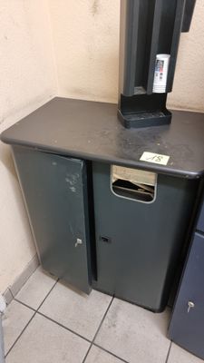 une poubelle noire posée à côté d'une poubelle en métal