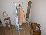 une photo d'une pièce avec un portant à vêtements et une chaise