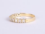 a close up of a gold ring with diamonds on a white surface