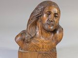 une statue en bois représentant un homme aux cheveux longs