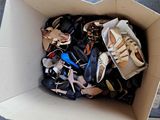 many pairs of shoes in a cardboard box on the floor