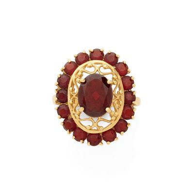un gros plan d'une bague ornée d'une pierre rouge entourée de grenats