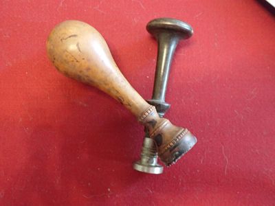 a wooden baseball bat and a wooden ball on a red surface