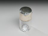une petite bouteille en verre avec un bouchon argenté