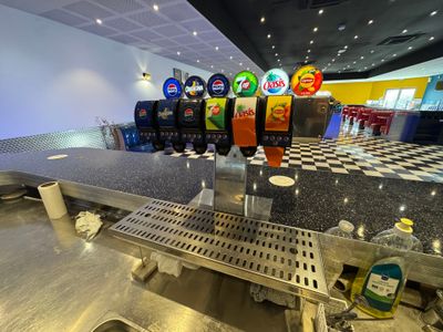 a lot of soda machines on the counter in this restaurant
