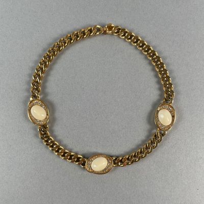 un bracelet en or orné de pierres blanches, monté sur une chaîne