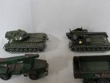 four toy army vehicles and a truck on a white surface