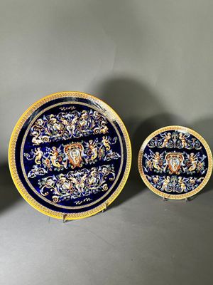 three blue and yellow plates with gold designs on them on a gray surface