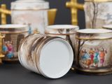 a group of coffee cups and a teapot on a table
