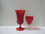 pair of red glass goblets sitting on a white table
