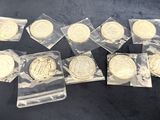 six different types of gold coins in plastic bags on a black surface